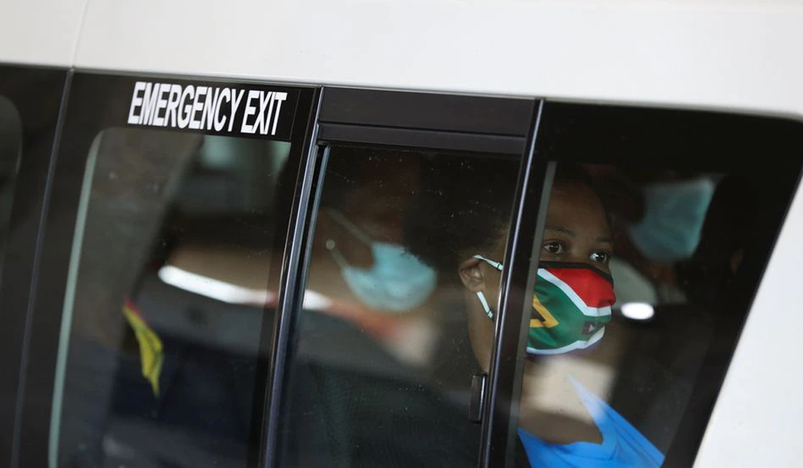 A passenger in a taxi wears a face mask with colours of the South African flag
